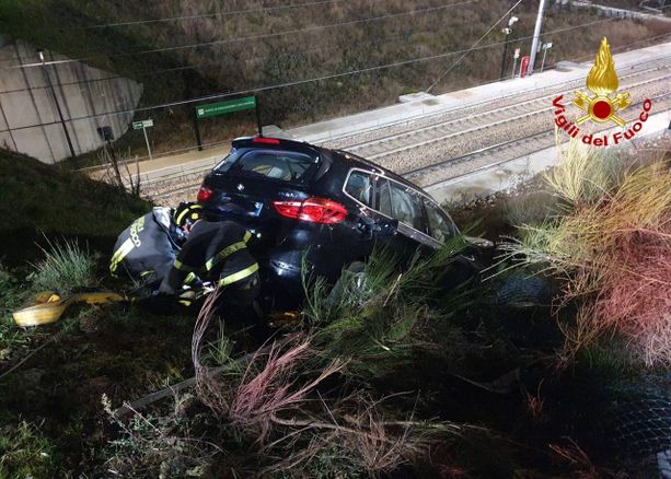 FOTO. Perde il controllo dell'auto e finisce in bilico sulla ferrovia: per recuperarlo servono i vigili del fuoco