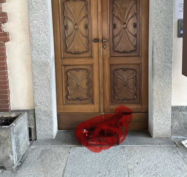 Un gatto nero morto davanti alla porta del municipio